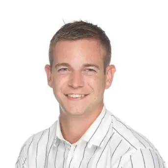 Alex Graham professional headshot in a white striped dress shirt smiling.