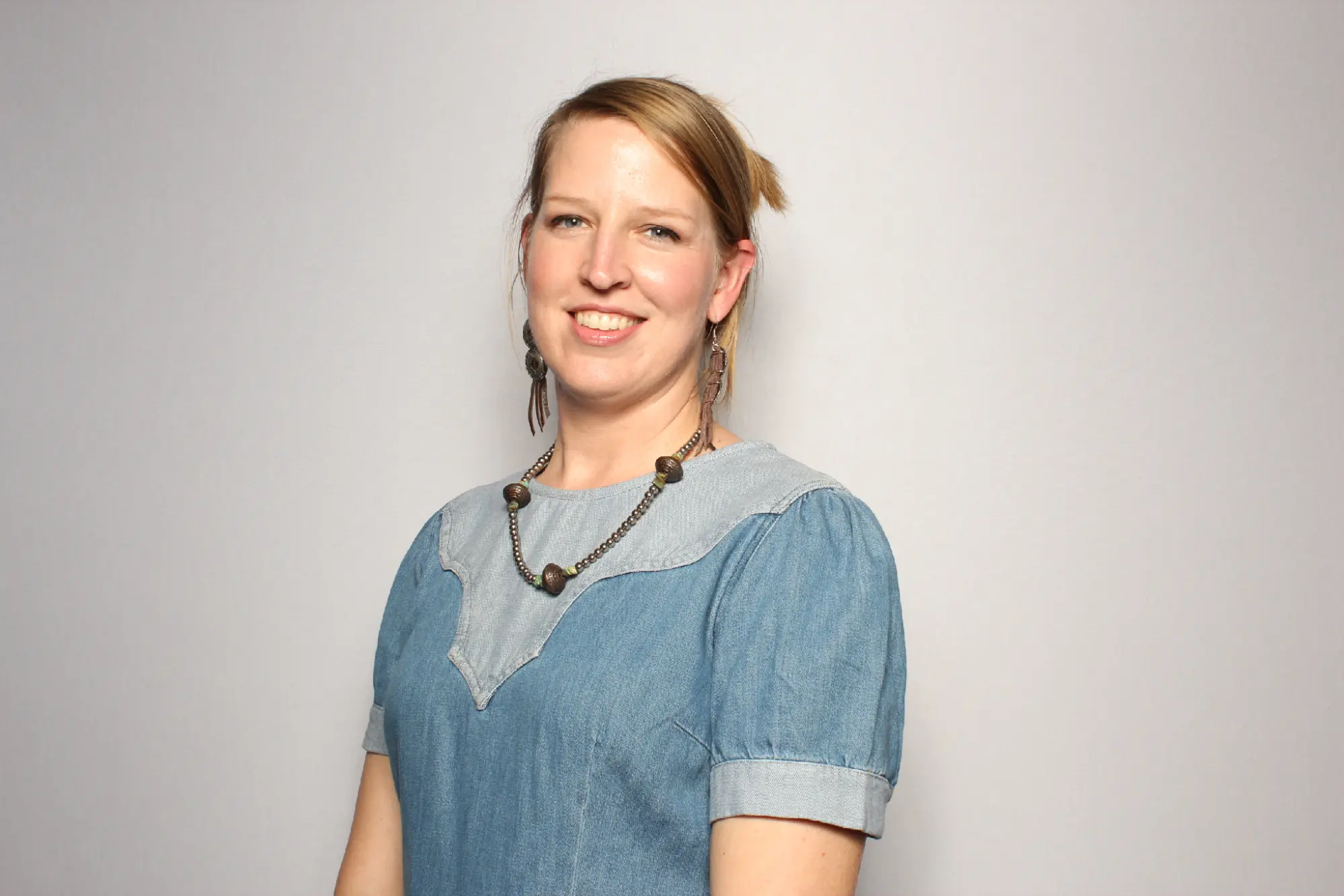 Helen Orme, General Counsel at Genesis Research Group, smiling in a professional headshot wearing a denim dress.