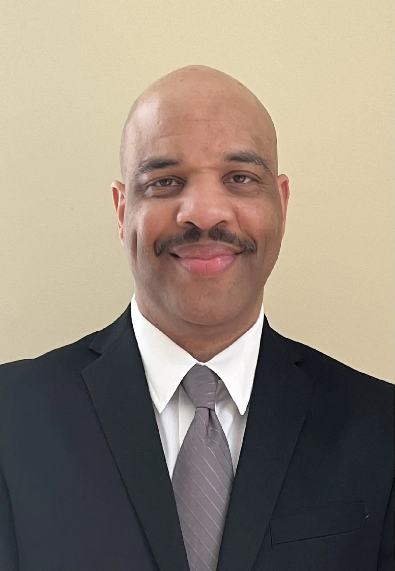 Michael James headshot in a black suit and grey tie.