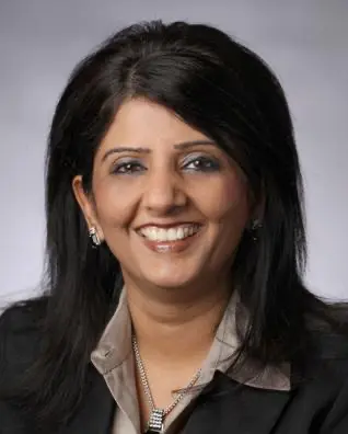 Priti Jhingran professional headshot smiling in a black blazer and grey collared shirt